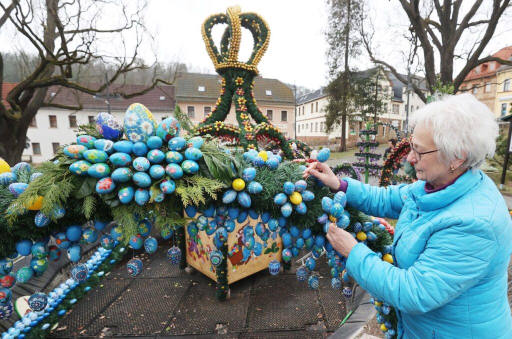 Eine Frau schmückt für den Osterpfad Vogtland